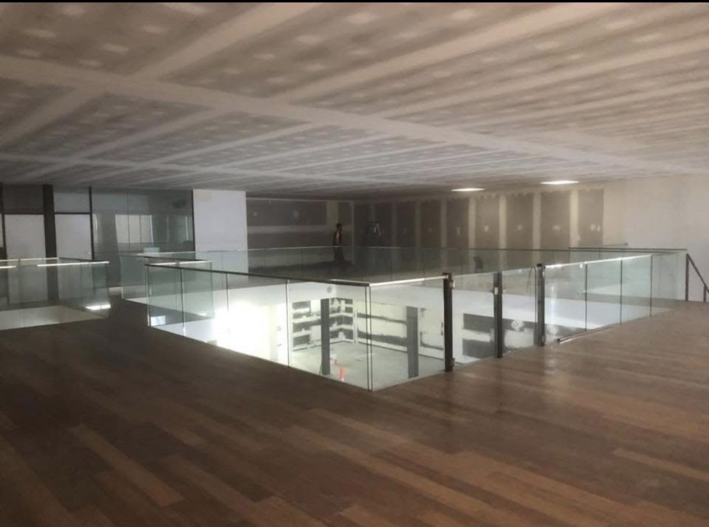 Mezzanine with timber floor and glass balustrade under a new plasterboard ceiling
