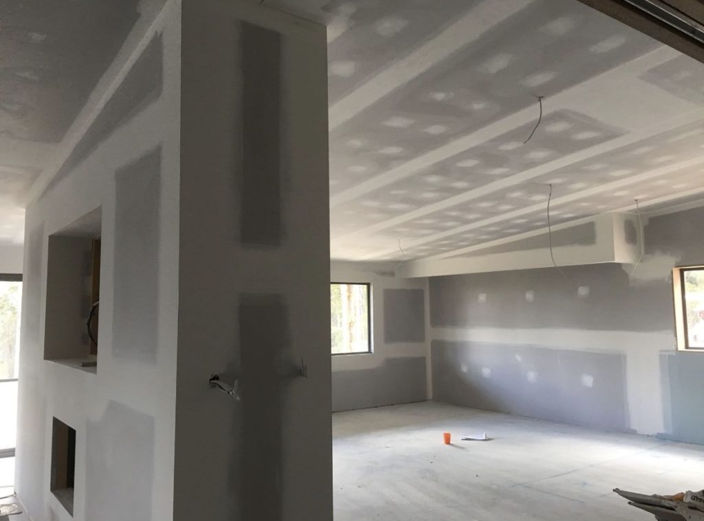 Plasterboard walls and ceiling with set joints in an empty open-plan room